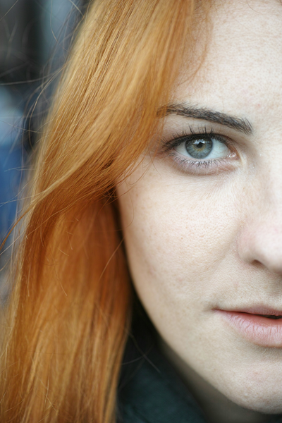 Женщина с рыжими волосами и зелёными глазами.