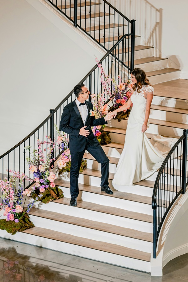 Жених и невеста, спускающиеся по лестнице.